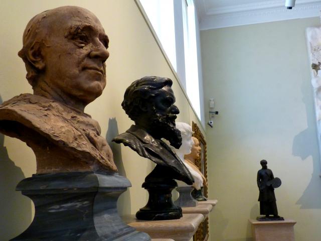 Alignement de bustes sculptés de différentes matières (terre, bronze, marbre) exposés au musée Denys-Puech, sur des tablettes contre le mur