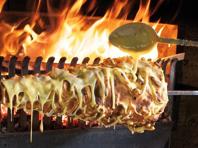 Cuisson d'un gâteau à la broche, spécialité aveyronnaise conique, au feu de bois. La pâte coule pour former les picots