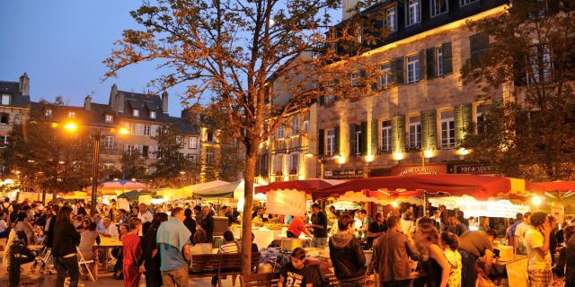 Foule de personnes présentes au marché gourmand nocturne de l'été, sur une place historique de Rodez