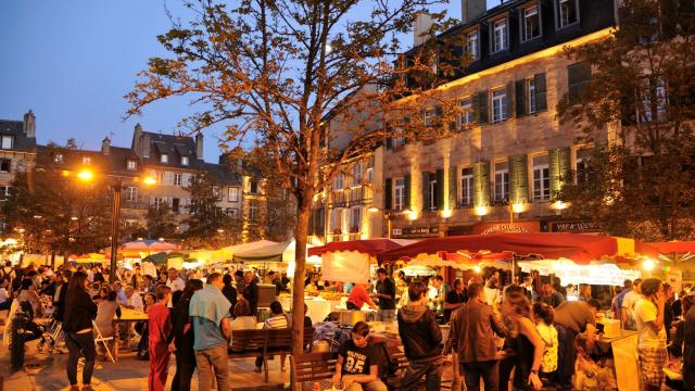 Foule de personnes présentes au marché gourmand nocturne de l'été, sur une place historique de Rodez