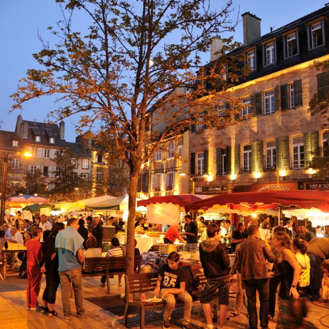 Foule de personnes présentes au marché gourmand nocturne de l'été, sur une place historique de Rodez