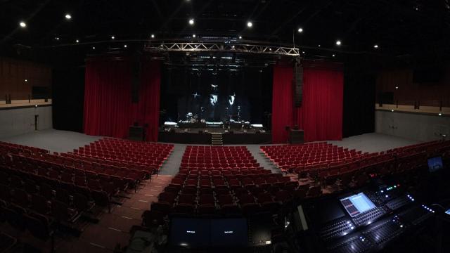 Salle de spectacle de l'Amphithéâtre vide avec des gradins et rideaux rouge