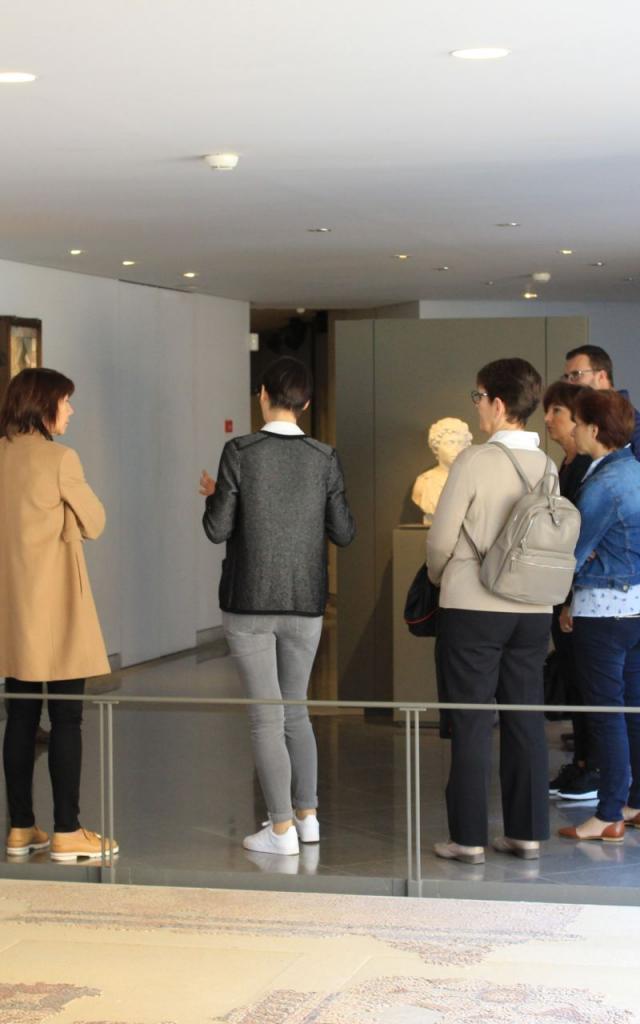 Groupe de visiteurs autour de la guide, au musée Fenaille