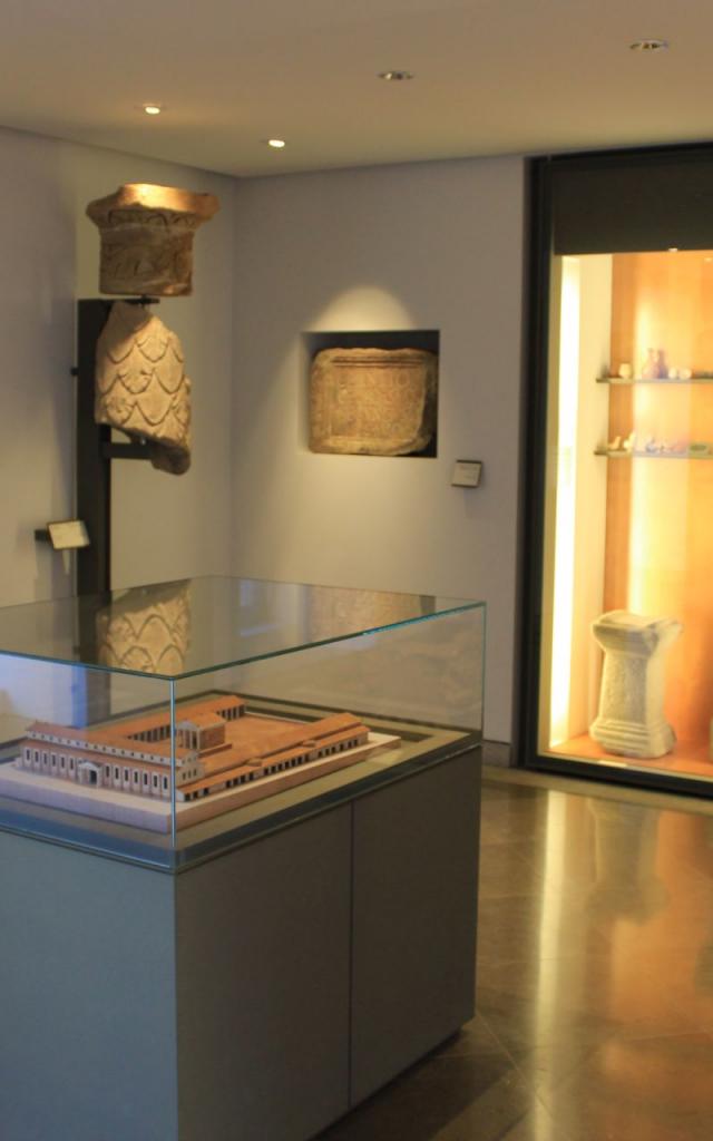 Maquette historique de Rodez sous verre, exposée au musée Fenaille, devant des vitrines aux objets archéologiques