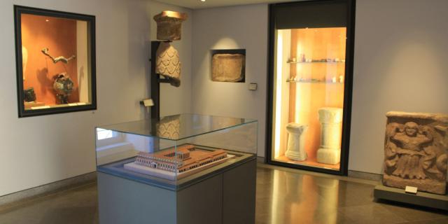 Maquette historique de Rodez sous verre, exposée au musée Fenaille, devant des vitrines aux objets archéologiques