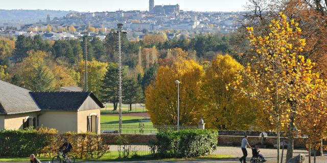 Enfants jouant aux jeux de bois sous les yeux de leurs parents, au parc de Vabre, avec vue sur la cathédrale au loin