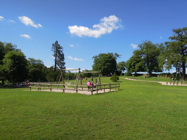 Famille s'amusant aux balançoires au milieu du Parc de Vabre à Rodez