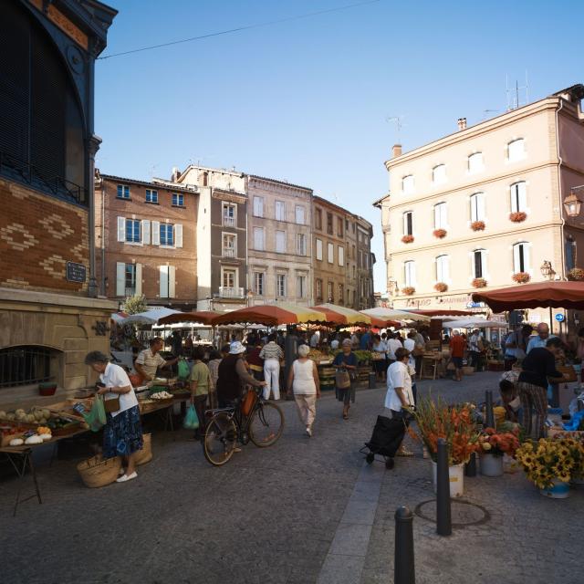 Foule de personnes avec leur panier ou leur vélo, au marché sur une place d'Albi