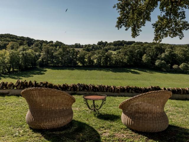 Deux fauteuils de type Loveuses face à la nature et un mur de pierres au Château de Labro