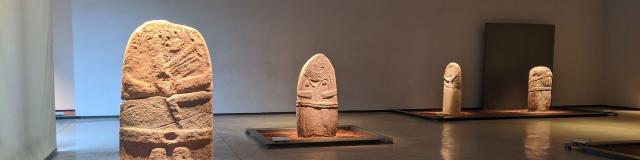 Statues-menhirs du musée Fenaille disposées autour de la Dame de Saint-Sernin dans une salle dédiée