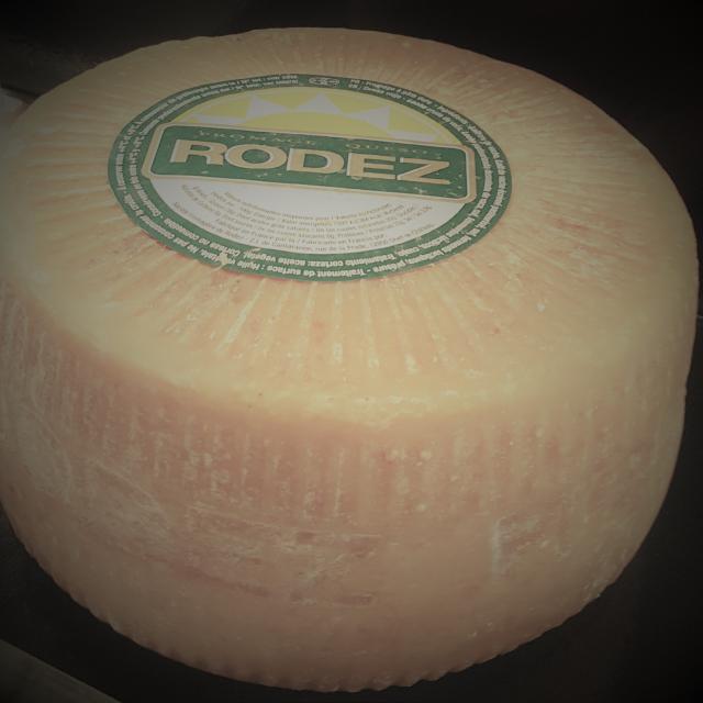 Meule ronde entière de fromage Le Rodez avec son étiquette au sommet blanche et verte