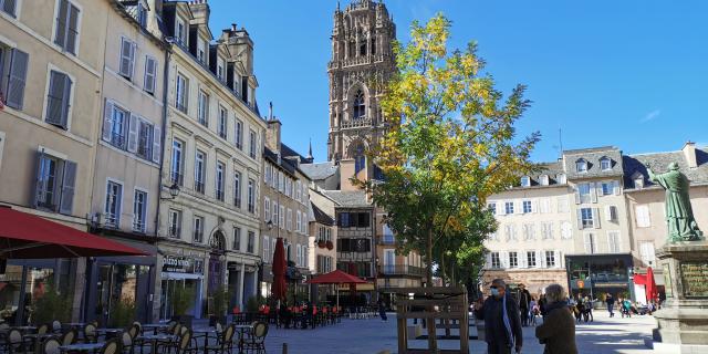 Clocher de la cathédrale vu depuis la place de la Cité et ses terrasses, avec des personnes s'y promenant