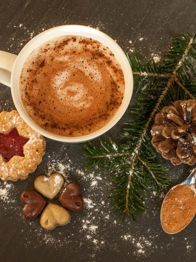 Chocolat chaud, gâteau sec et chocolats en forme de cœur, avec une décoration de branche de sapin et pomme de pin