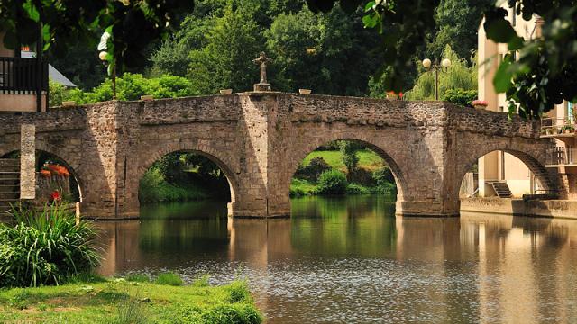 Pont en pierre avec sa croix au-dessus de la rivière Aveyron au Monastère