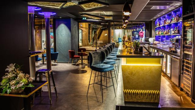 Ambiance feutrée au Bar à cocktails le 16.45, avec son comptoir et ses chaises hautes en velours gris