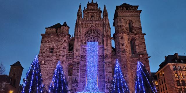 Pour Noël, à la nuit tombée, une cascade de lumière bleue descend de la rosace de la cathédrale vers la place en contrebas, au milieu de sapins illuminés