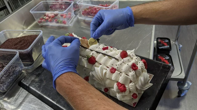 Confection d'un vacherin aux framboises par le Glacier de l'Aubrac : ajustement du décor